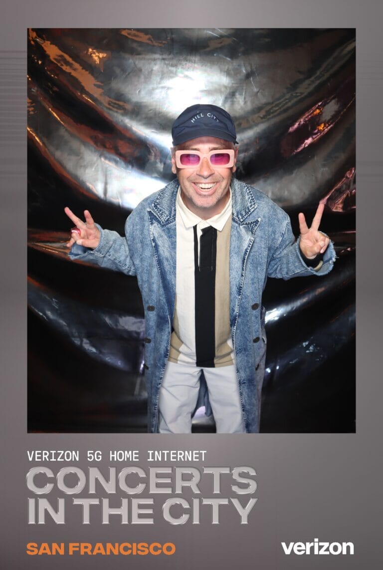 Case Studies 28 Guest in pink glasses and a denim jacket makes peace signs in a Verizon Concerts in the City San Francisco frame.