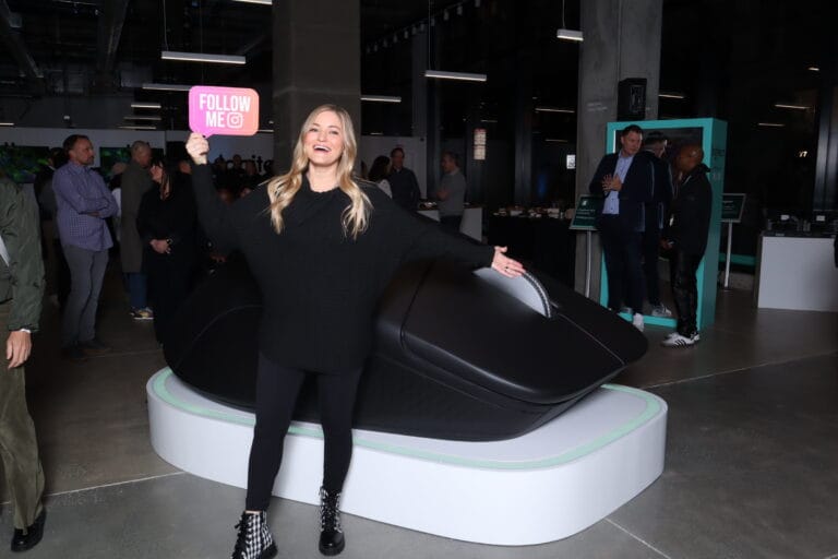Case Studies 29 Guest holds a pink prop sign while posing beside a giant computer mouse at the Logitech experience store.