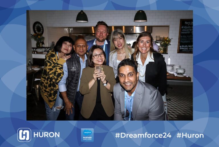 Atlanta Photo Booth Rental 4 A group of guests poses indoors in a blue Huron-branded event photo frame.