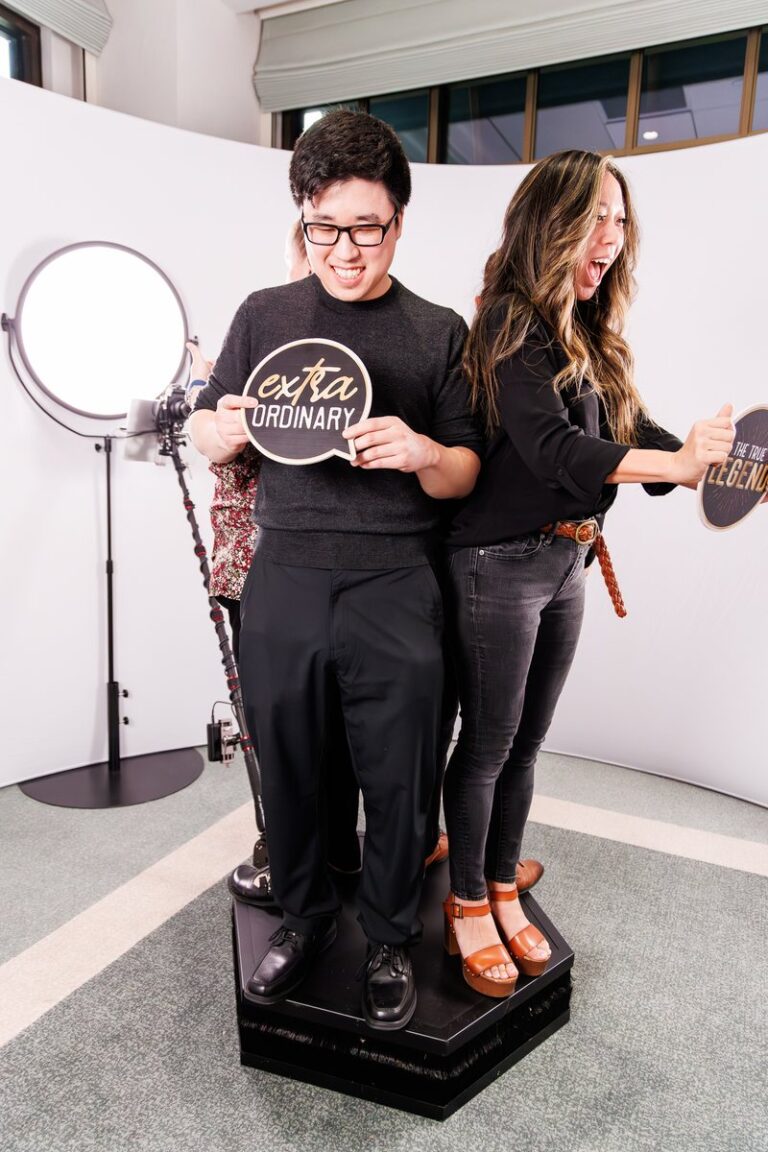 Two guests stand on a 360 video platform between circular lights.