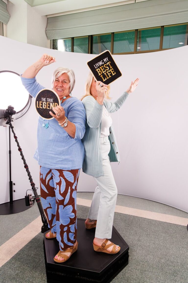 Atlanta Photo Booth Rental 2 Two guests pose together on a 360 platform in front of a curved white backdrop.