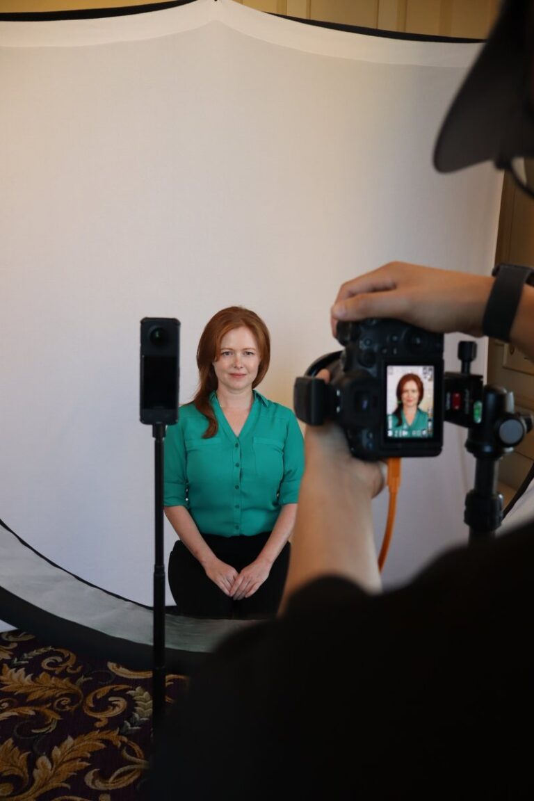 Portland Photo Booth Rental 3 Photographer frames a seated guest in a green blouse against a pale backdrop.