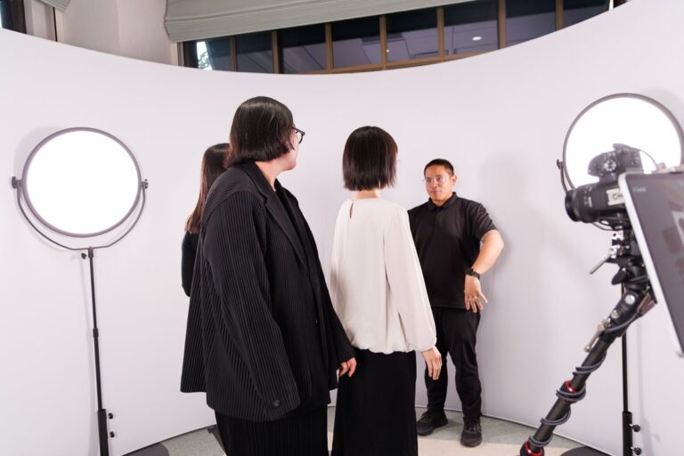 Three guests gather on the 360 set between two circular lights.