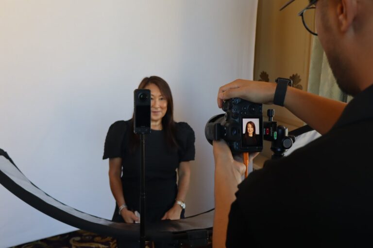 Atlanta Photo Booth Rental 3 Photographer frames a seated guest in a dark top against a white portrait backdrop.
