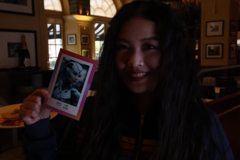 Guest in a dark top displays a portrait print inside an event venue.