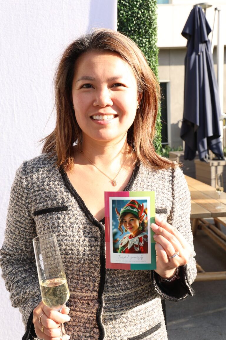 Portland Photo Booth Rental 1 Guest in a patterned top holds a colorful portrait print outdoors.