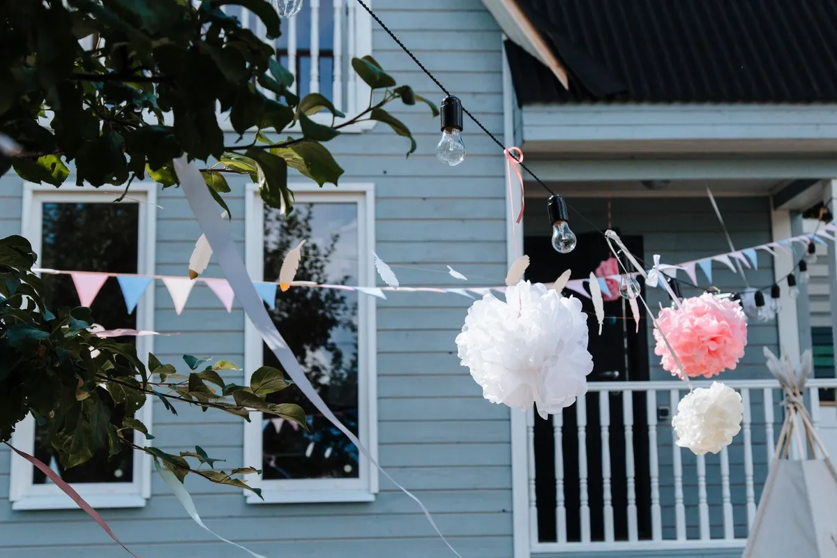 Key Elements to Consider When Planning a Corporate Photo Booth Experience 1 Elegant outdoor garden with hanging pom poms and bunting, perfect for a corporate photo booth setting.