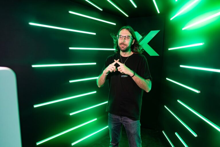 Atlanta Photo Booth Rental 6 Guest in a black T-shirt poses with hands together inside the green LED booth.